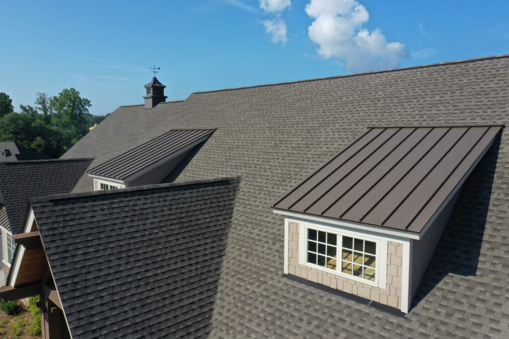 An aerial view of a residential roof with dark gray slate tiles